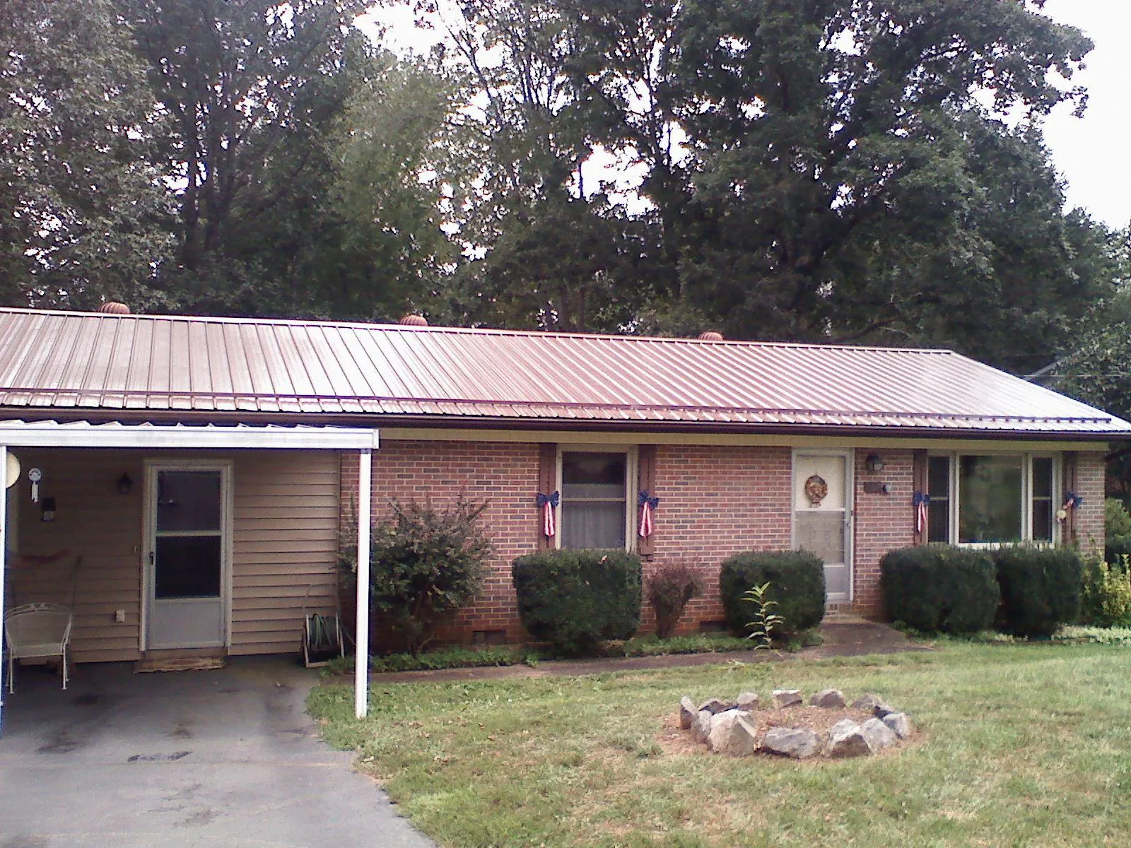 Bronze metal roof and carport on a brick ranch home — Roof Repair work by our crew in Sandston