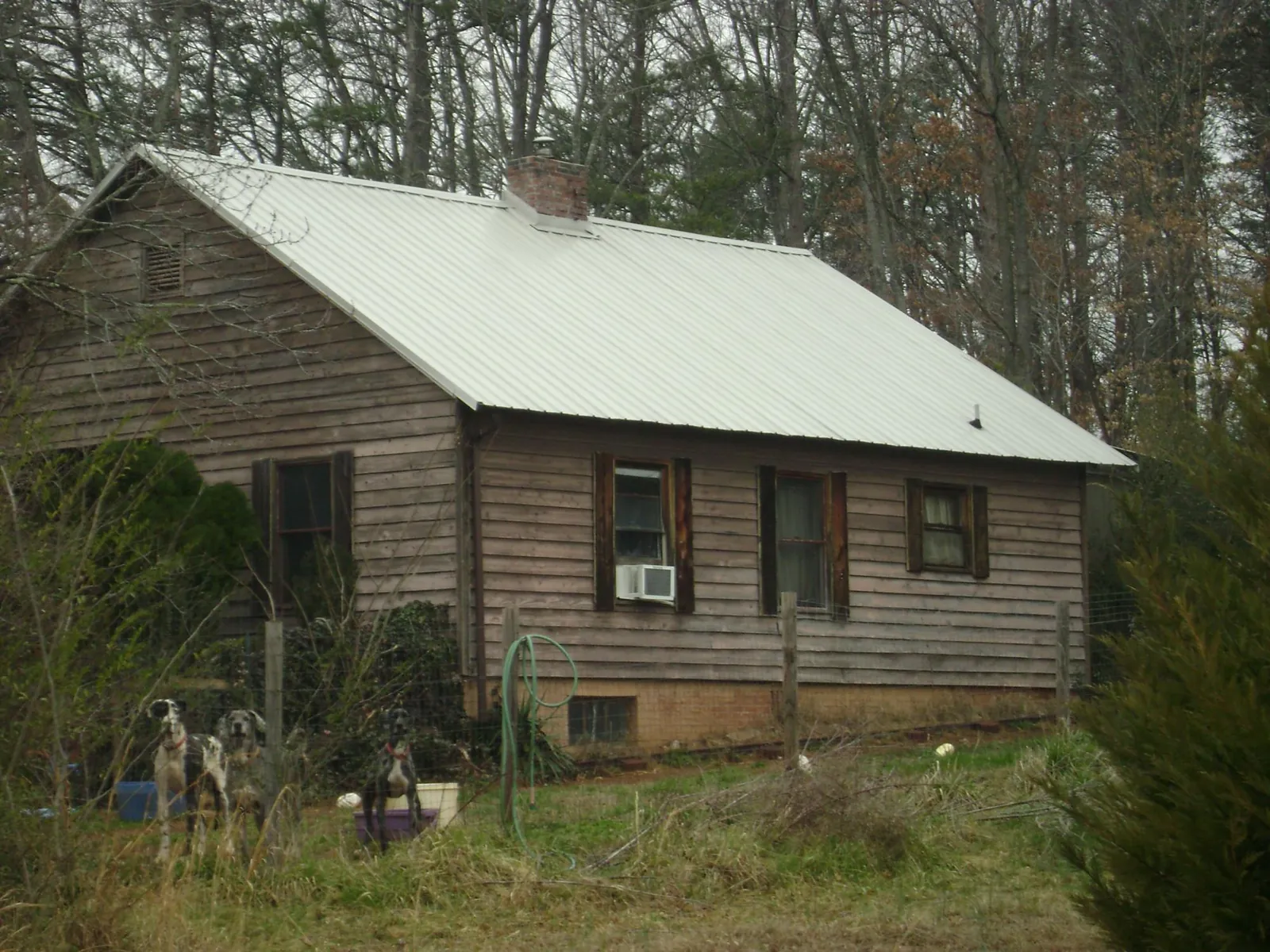 White metal roof on an old wood sided farmhouse, from a Metal Roof Installation job in Sandston